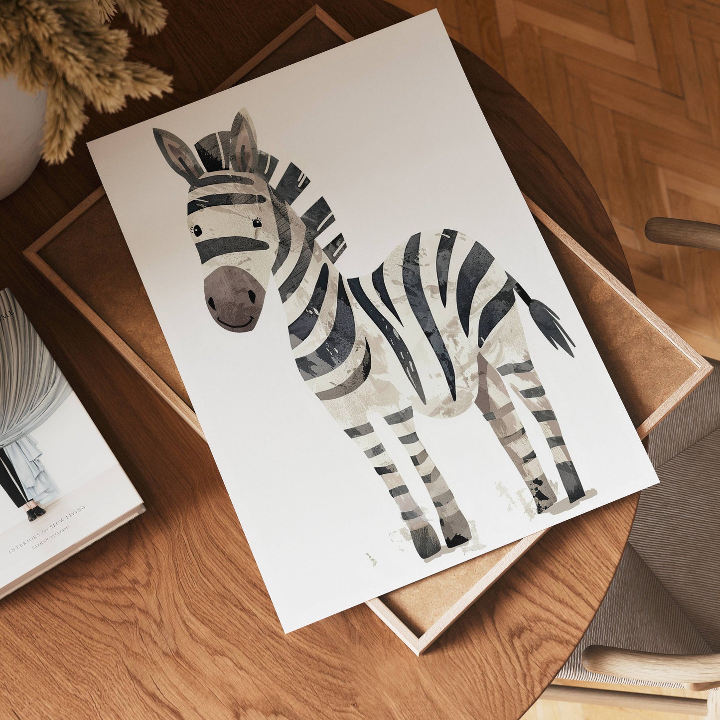 The no-9 paper, featuring a watercolor zebra illustration, rests on a wooden table beside a tray, a book, and a vase of dried flowers, creating a cozy, softly lit scene.