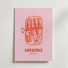 Postern Sardines From Portugal från Bozetto har en rosa bakgrund med en orange öppen sardinburk märkt "SARDINE" som visar fem sardiner. Den feta och kursiva texten nedan lyder "SARDINES Portugal" och hyllar Portugisisk matkultur.