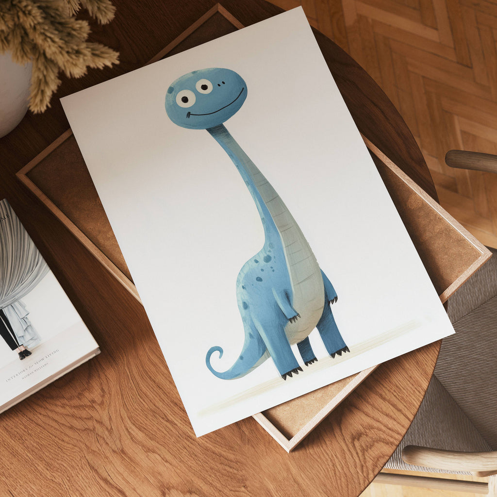 The no-9 poster rests on a wooden table, showcasing a cute blue cartoon dinosaur with a long neck, big eyes, and a friendly smile, surrounded by a cozy scene with a book and a vase of dried flowers.