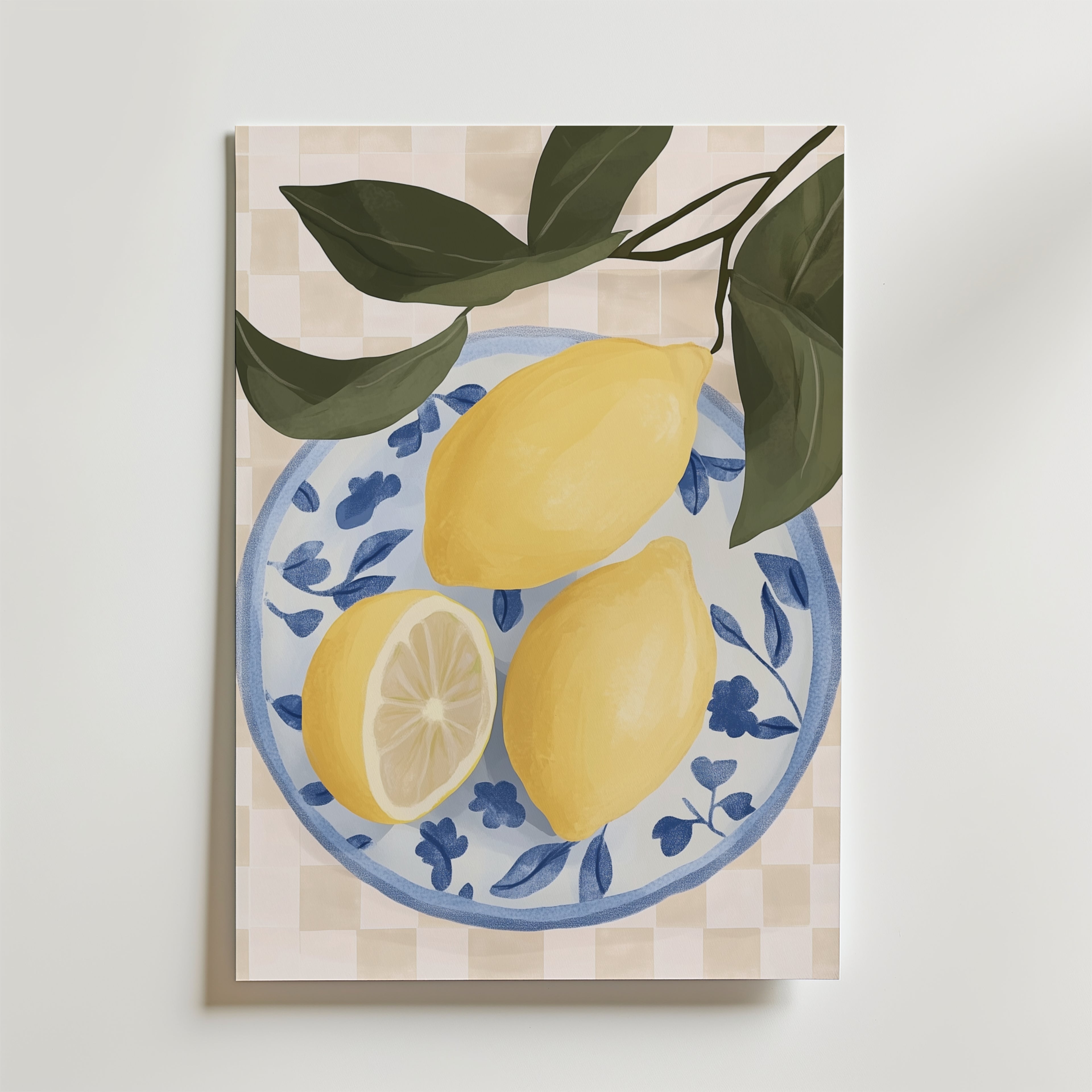 Bozetto Lemon Table Poster visar två hela citroner och en citronhalva på en blåvit blommig tallrik med gröna blad mot en beige rutig bakgrund, elegant tryckt på premium art paper.