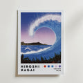 Bozetto Hiroshi Nagai Diamond Wave Poster föreställer en stiliserad blå våg som ringlar sig mot stranden, uppbackad av en stadsbild och berg, med "Hiroshi Nagai" och "Tokyo 1973" under i en nostalgisk design.