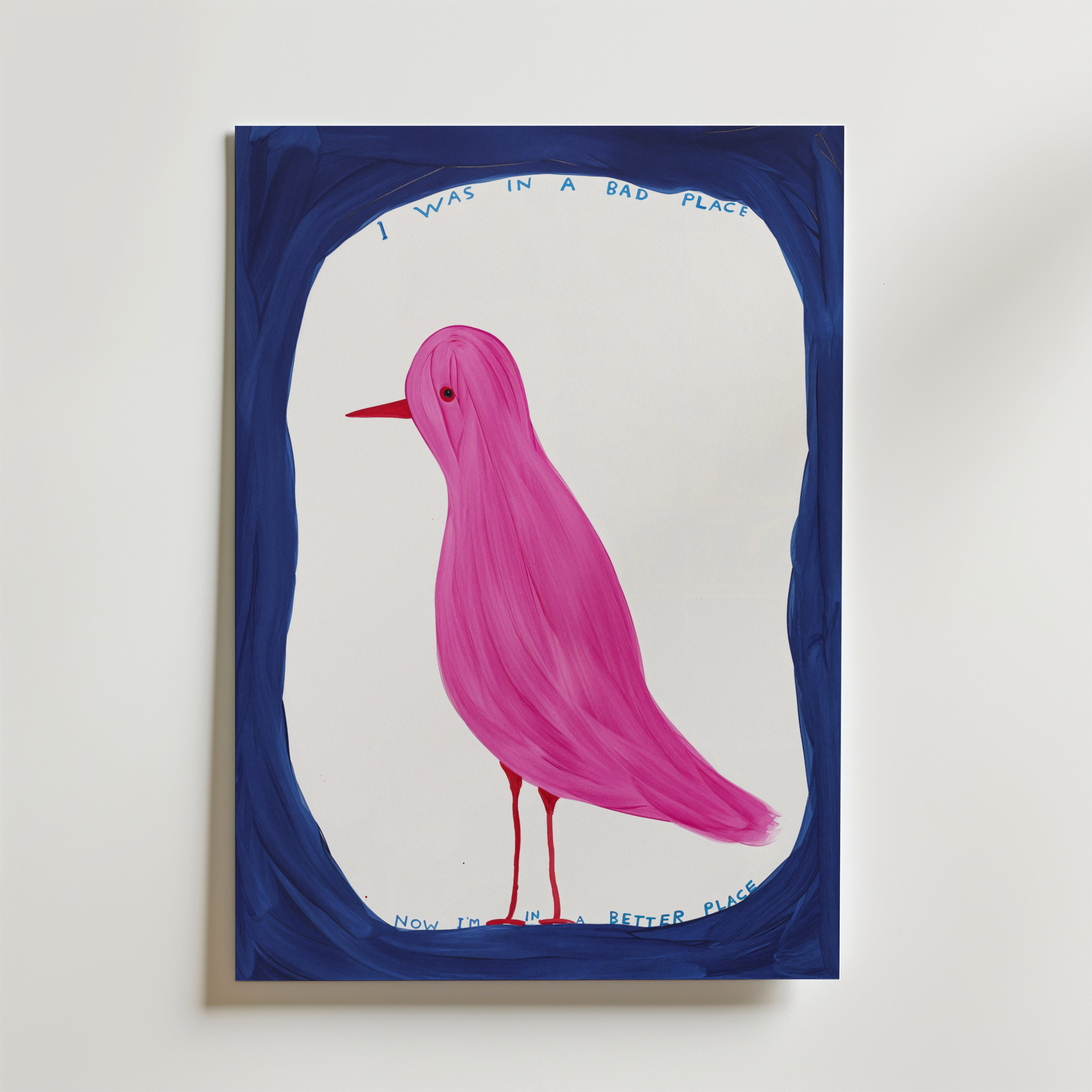 Affischen Pink Bird Poster av Bozetto visar en rosa fågel med röd näbb, inramad i blått. Den handskrivna texten ovan lyder "Jag var på en dålig plats" och nedan "Nu är jag på en bättre plats".