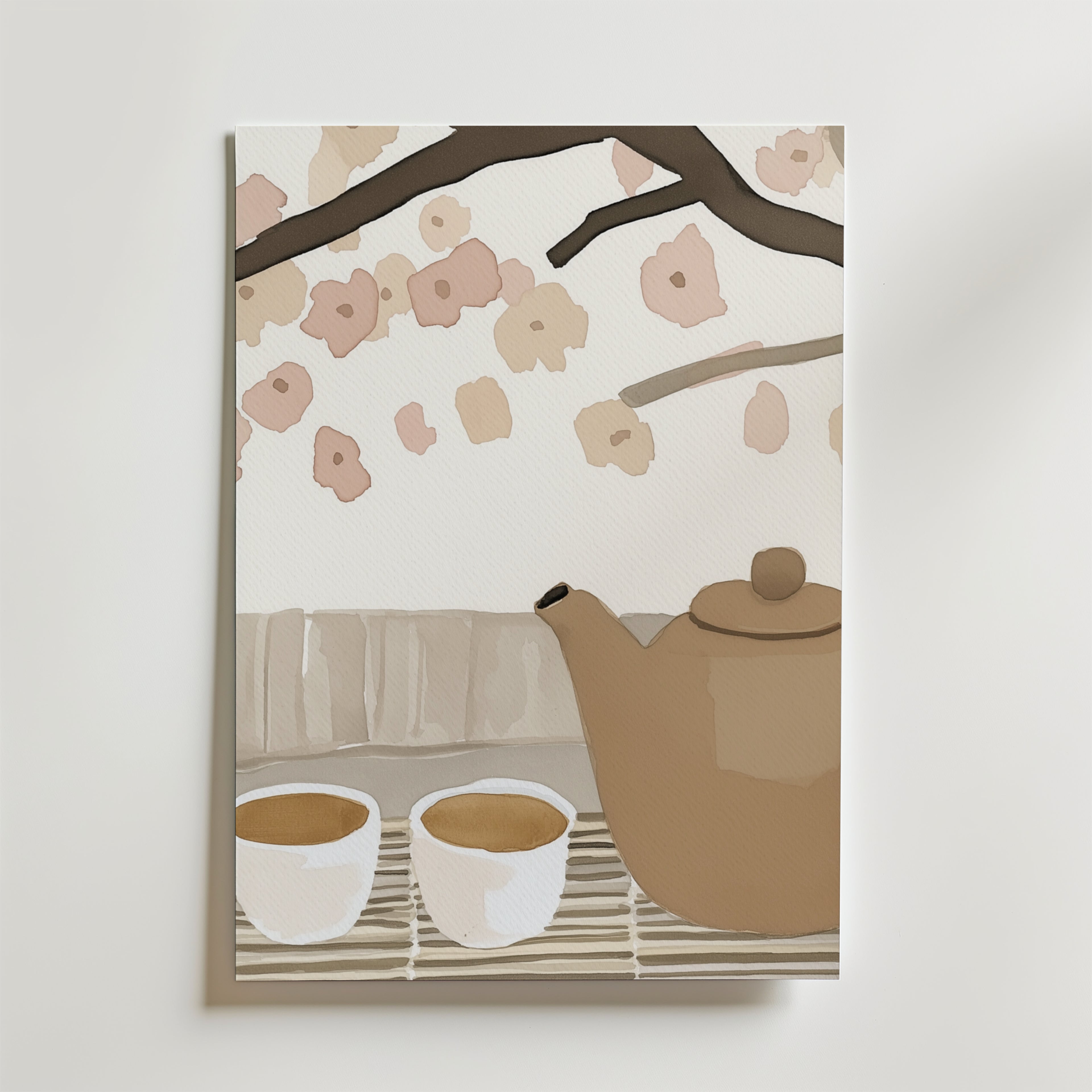 Bozetto Tea In Bloom Poster föreställer en brun tekanna och två tekoppar på en matta med körsbärsblommor, mot en vit vägg - perfekt för att skapa en harmonisk atmosfär.