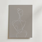 Bozettos White Line Woman Silhouette Poster visar minimalistisk konst av en kvinnlig figur med en knut på grå canvas, tryckt på premiumpapper med en lyxigt matt yta för en elegant och neutral look.