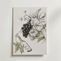 Bozetto Vintage Grape And Floral Poster föreställer svartvita druvor, stora blommor och mjuka gröna blad med en vinflaska på snedden. Postern är tryckt på premiumpapper och är signerad "Lucy" i nedre högra hörnet.