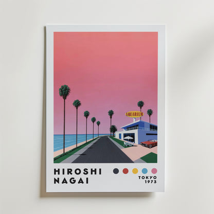Bozetto Hiroshi Nagai Sunset Coast Poster föreställer en rosa solnedgång över en palmkantad kustväg som leder till en akvariebyggnad, med "Hiroshi Nagai Tokyo 1973" och färgade prickar längst ner.