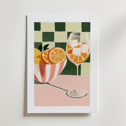 Bozetto's Tropical Charm Drink Poster föreställer en skål med apelsinskivor, ett vinglas med apelsinskivor och is, på en rosa med grönvitrutig bakgrund, tryckt på FSC-certifierat premiumpapper.