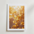 Morning Haze Poster by Bozetto föreställer gula blommor i mjukt solljus med en drömsk oskärpa, placerad i en vit ram på en ljus vägg och tryckt på FSC-certifierat premiumpapper för en högkvalitativ finish.