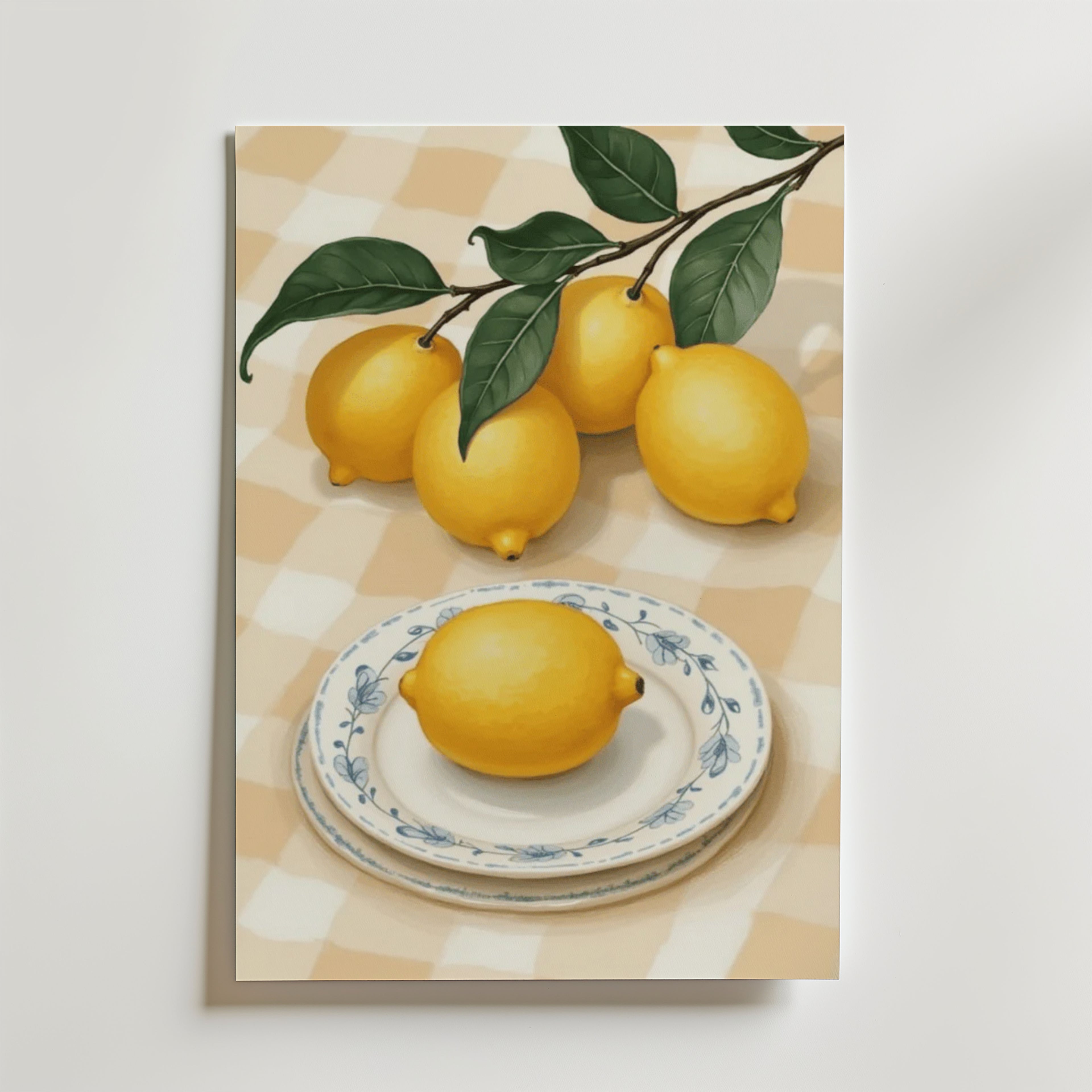På Lemon Picnic No.2 Poster by Bozetto syns fem ljusgula citroner - en på en dekorativ tallrik, fyra på en bladgren - på en beige- och vitrutig duk. Tryckt på premiumpapper och FSC-certifierat för hållbarhet.