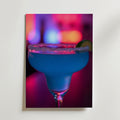 Bozetto Blue Lagoon Drink Poster föreställer ett margaritaglas med saltad kant och limeklyfta, fyllt med en blå cocktail. Den lyxigt matta ytan framhäver levande neonrosa, lila och blå lampor i bakgrunden.