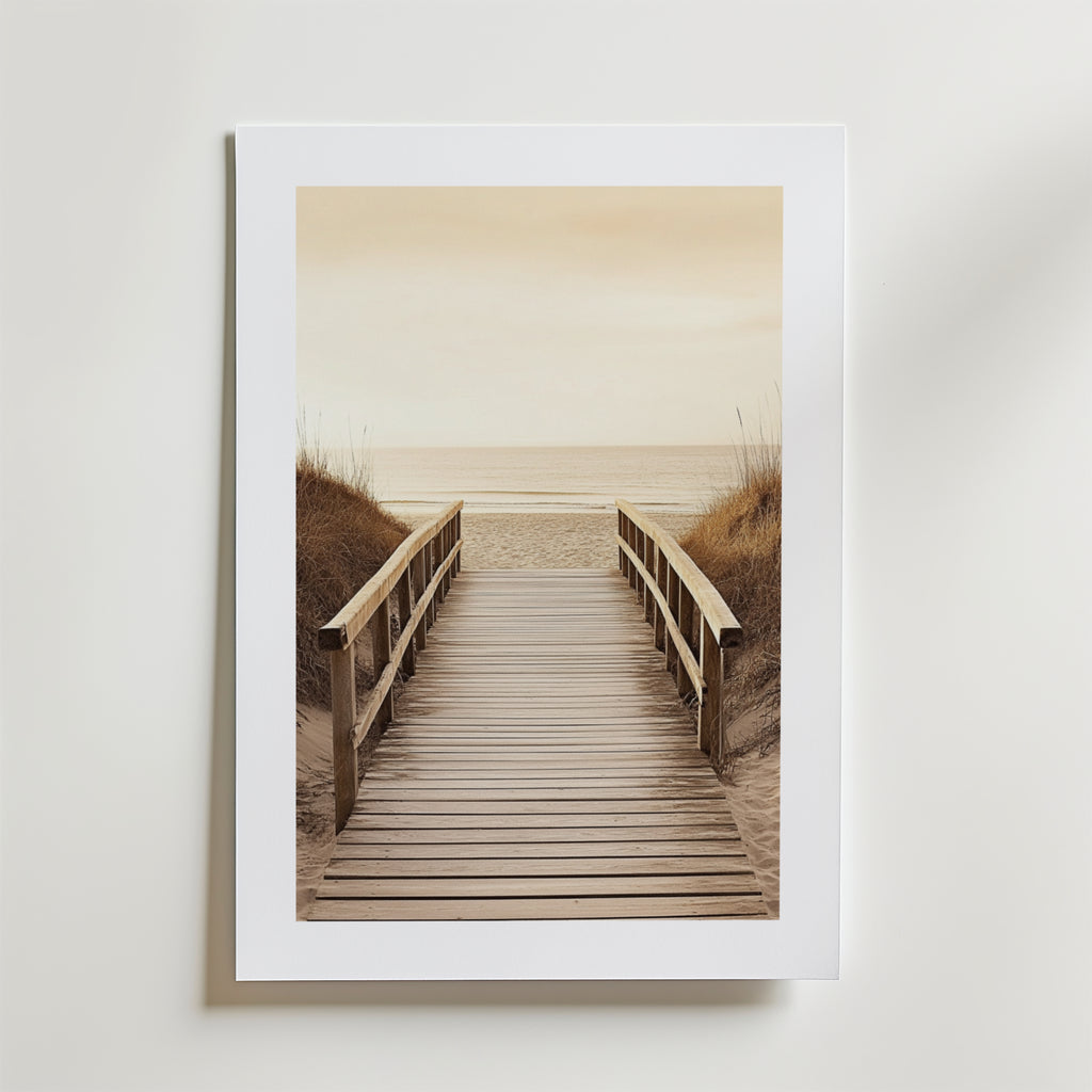 Beach Path Poster by Bozetto föreställer en träpromenad med räcken genom sanddyner mot en lugn strand och hav under en molnig himmel, tryckt på FSC-certifierat premiumpapper med lyxigt matt yta.