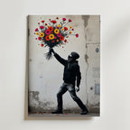 En maskerad figur i svart huvtröja står vid en sprucken vägg, redo att kasta en färgglad bukett. Bozetto Flower Molotov Poster poppar med street art på premiumpapper med lyxig matt yta för en urban känsla.