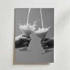Två händer håller i martiniglas medan mjölkstänk möts i luften. Cheers Martini Drink Poster från Bozetto har denna slående svartvita bild på premiumpapper, vilket gör den perfekt för modern inredning med sin släta bakgrund.