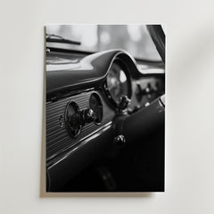 Bozetto's Old School Car Dashboard Poster visar ett svartvitt foto av en klassisk bils ratt, hastighetsmätare och vintagevred, tryckt på premiumpapper och uppsatt på en ljus vägg.