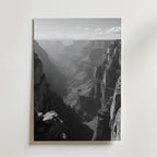 Grand Canyon Shadows Poster by Bozetto: Svartvitt foto med karga klippor och en skuggig dal under en delvis molnig himmel, tryckt på FSC-certifierat premiumpapper med elegant matt yta. Perfekt som Grand Canyon väggkonst.