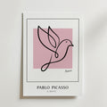 Picasso Bird of Hope Poster från Bozetto visar minimalistisk linjekonst av en duva över en rosa kvadrat. Nedanför är "PABLO PICASSO" och "A DOVE" tryckta i feta svarta versaler.