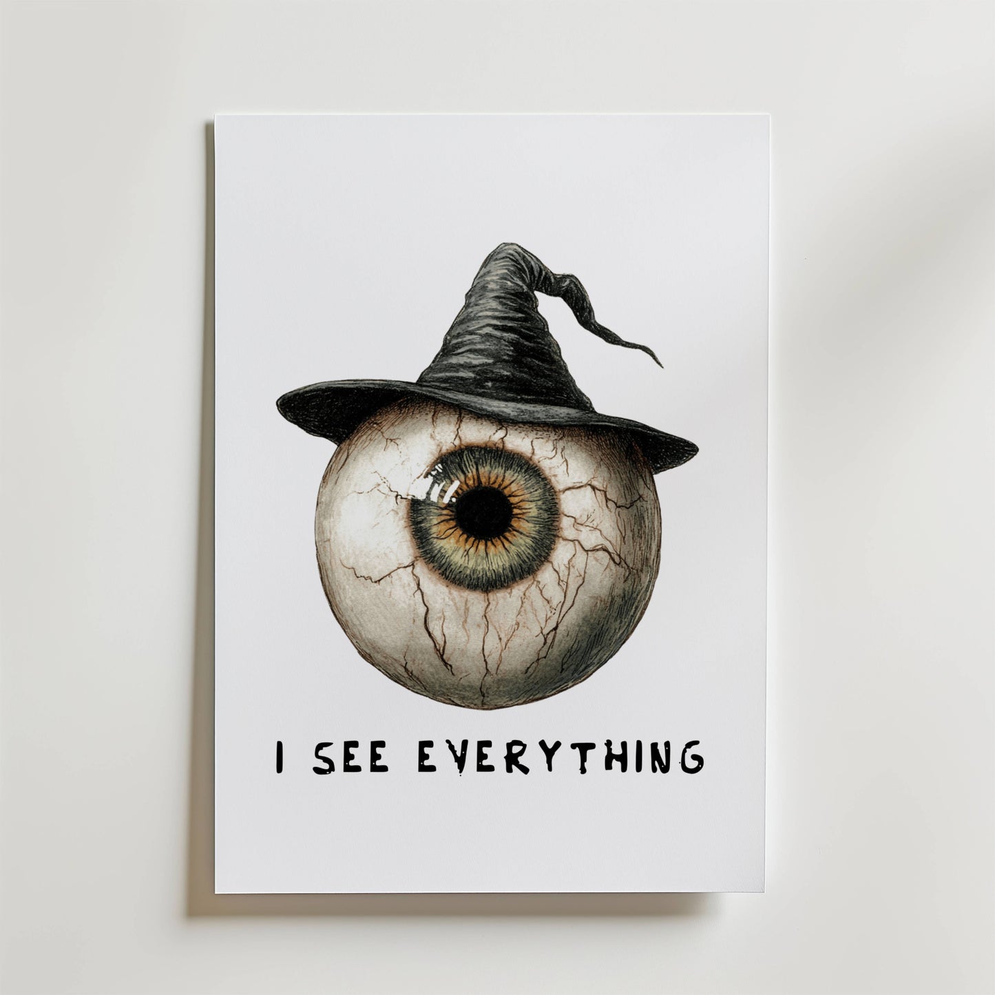 Bozetto I See Everything Poster föreställer en stor ådrig ögonglob i en häxhatt som blandar mörk elegans. "I SEE EVERYTHING" står under, vilket gör denna unika öga poster perfekt för effektfulla väggdekor på en vit bakgrund.