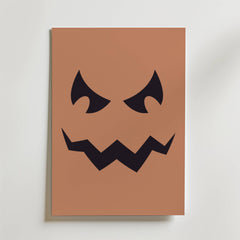 Bozetto Pumpkin Grin Poster föreställer ett minimalistiskt svart jack-o-lantern ansikte med arga ögon och en taggig mun på en brun bakgrund - perfekt som en unik höstdekoration eller väggkonst med pumpatema.
