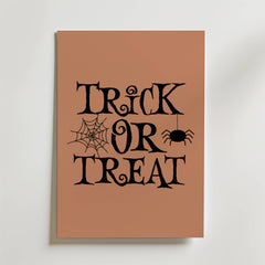 Bozetto Trick Or Treat Poster är en brun Halloween-poster med svart spöktext och ett spindelnät och en hängande spindel för extra Halloween-stämning.