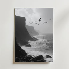 Seaside Flight Poster från Bozetto föreställer en svartvit klippig kustlinje med dramatiska klippor, vågor som slår ner och måsar som flyger under en dimmig himmel. Tryckt på premiumpapper med en lyxig matt finish för en elegant look.