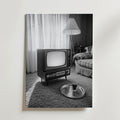 Ett svartvitt foto av ett vintagevardagsrum med en gammal TV, rutig soffa, bricka på shagmatta och skira gardiner - precis som Bozetto Vintage Living Room Poster, tryckt på FSC-certifierat premiumpapper.
