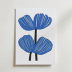 Bozetto Blue floral Poster visar två stiliserade blå blommor med djärva svarta stjälkar och vita accenter på premiumpapper mot en enkel vit bakgrund.