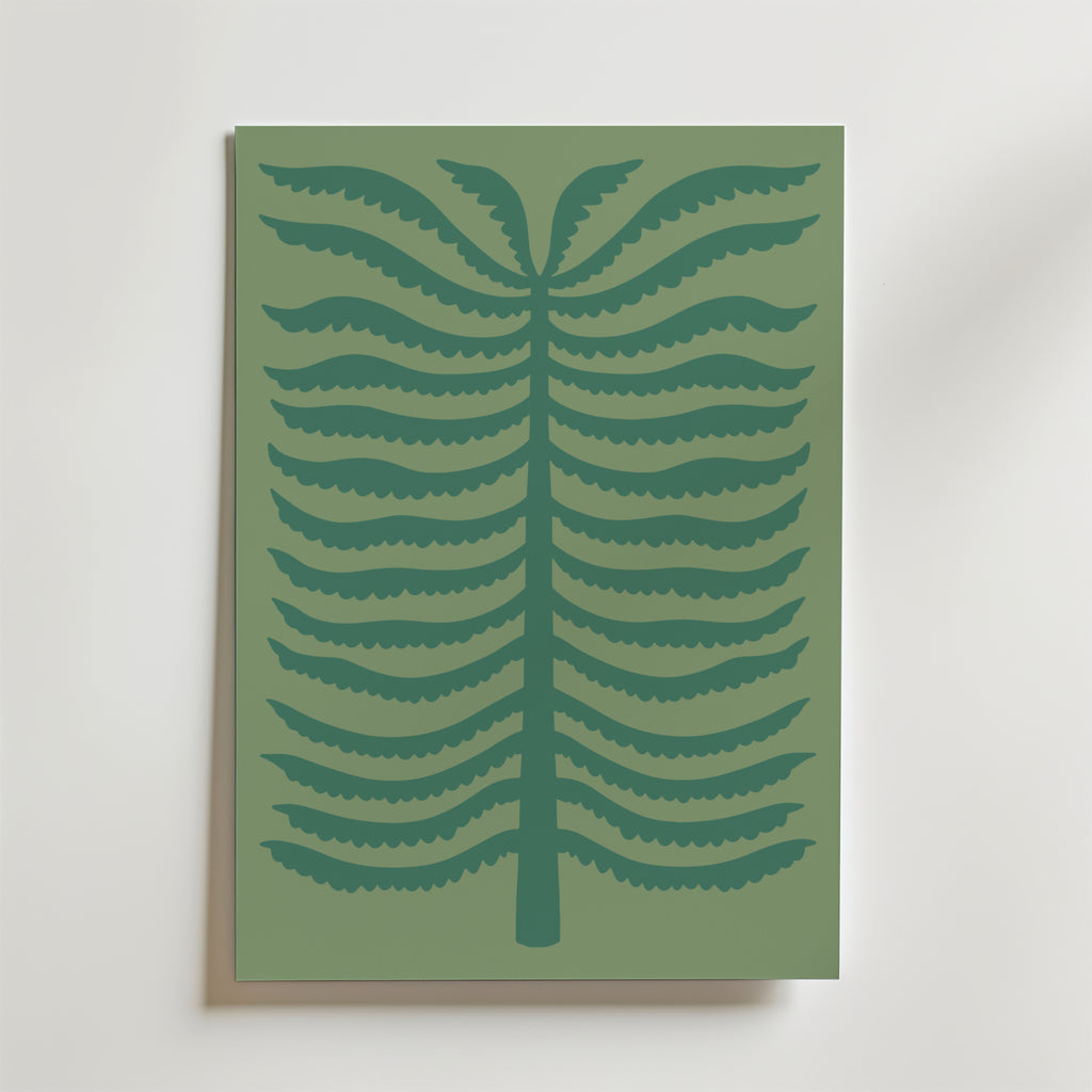 Quiet Palm Poster från Bozetto föreställer en minimalistisk stiliserad ormbunke med mörkgröna symmetriska grenar på en dovt grön bakgrund, inramad och placerad mot en ljus vägg.