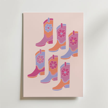 Bozetto Pink Cowboy Boots Poster har sex livfulla, blommiga cowboyboots i rosa, lila, orange och rött på en ljusrosa bakgrund - perfekt för att skapa en rolig westernkänsla i alla rum.