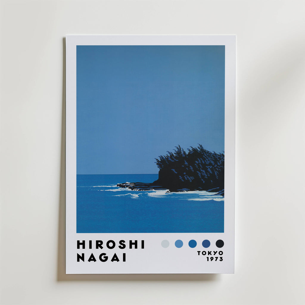 Bozetto Hiroshi Nagai Coastal Stillness Poster föreställer ett minimalistiskt havslandskap med klippig kust och träd under en blå himmel, samt "Hiroshi Nagai, Tokyo 1973" och fem blå färgklickar tryckta längst ner.