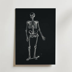 Dancing Skeleton Poster från Bozetto visar ett vitt anatomiskt skelett på en svart bakgrund, vilket skapar slående svartvit konst mot en vanlig vit vägg.