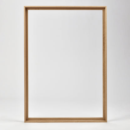 Bozetto Canvas Träram Ek är en enkel, tom tavelram i trä med en exklusiv träram, som står upprätt mot en vit bakgrund.