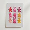 Bozetto Gummy Bear Grid Poster visar nio färgglada gummibjörnar i ett 3x3 rutnät på en vit bakgrund, med livfulla röda, rosa, lila och gula nyanser för en slående minimalistisk väggdekor.