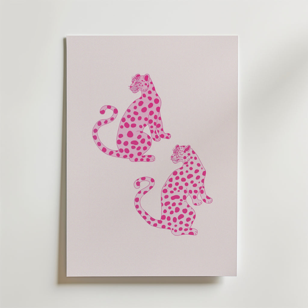 Bozetto Pink Leopard Twins Poster har ett minimalistiskt djurmotiv av två rosa leoparder med mörkare fläckar, som sitter rygg mot rygg på en pastellfärgad bakgrund - perfekt för modern inredning och visas vertikalt på en ljus yta.