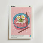 The Art of Umami Poster by Bozetto föreställer en ramen bowl med fläsk, ägg och salladslök, ätpinnar på toppen och körsbärsblommor på en rosa bakgrund - perfekt köksinredning för fans av japansk matkultur eller som en unik ramen poster.