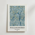 Bozetto William Morris Sweet Briar Poster visar den klassiska designen från 1887 med ljusblå blommor och beige blad på en blå bakgrund. Konstnärens namn och titel är tryckt under konstverket.
