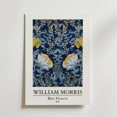 William Morris Blue Flowers Poster by Bozetto har ett symmetriskt blommönster i blå toner med subtila gyllene accenter, vita kanter och inkluderar konstnärens namn och titel nedan.