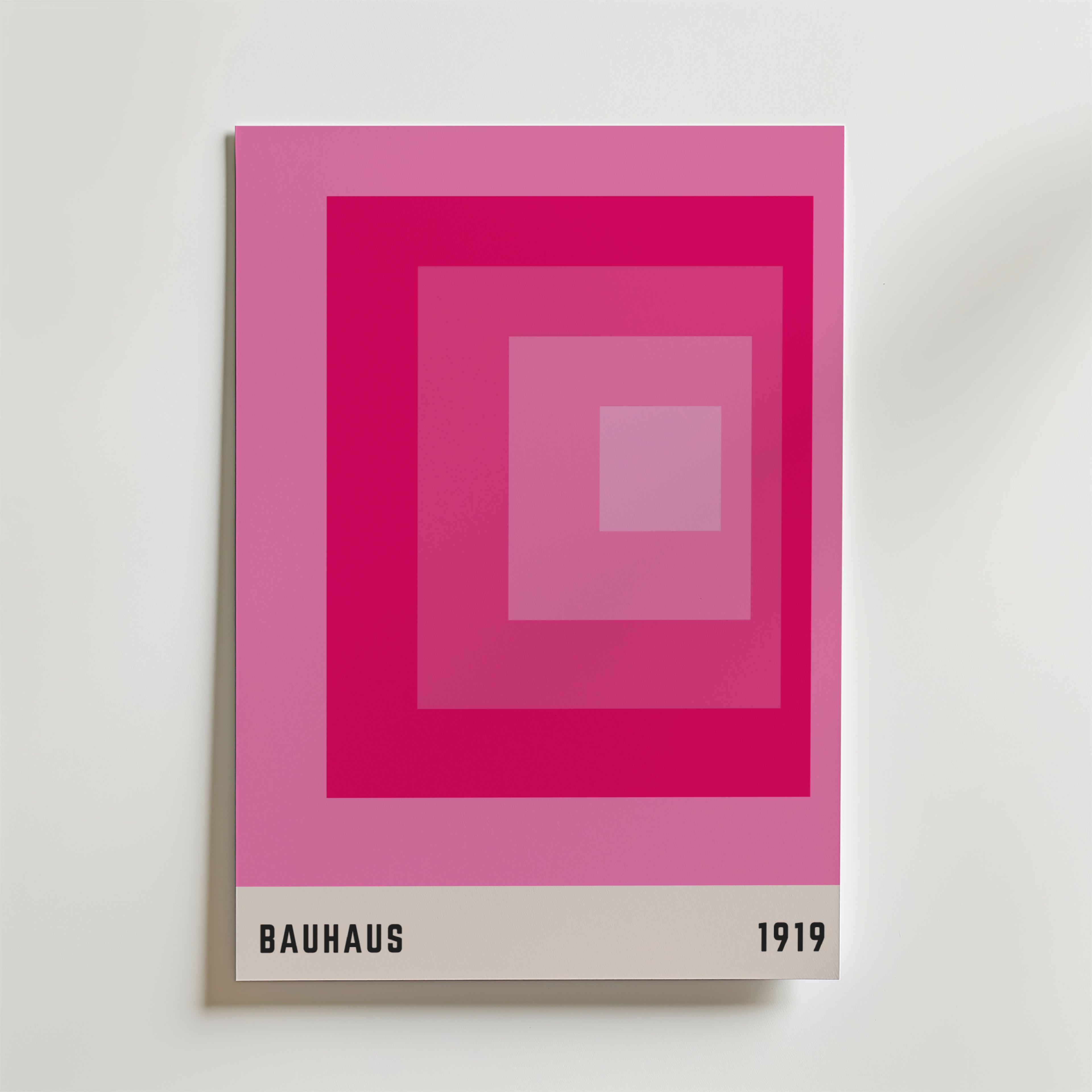 Bauhaus Pink Squares Poster från Bozetto har koncentriska rosa rutor och ett beige band med texten "BAUHAUS" och "1919", och blandar minimalistisk design med en hyllning till Bauhaus historia.