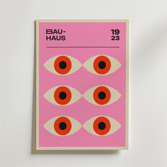 Bauhaus Gaze Poster by Bozetto är ett grafiskt konsttryck med sex stiliserade ögon på en rosa bakgrund, "BAUHAUS" uppe till vänster och "1923" uppe till höger, vilket skapar en modern och minimalistisk look.
