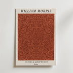 Bozetto William Morris Victoria & Albert Museum No. 6 Poster har titeln upptill, ett rött blommönster inspirerat av mönster av löv i mitten och branding nedtill, allt på en vit bakgrund.